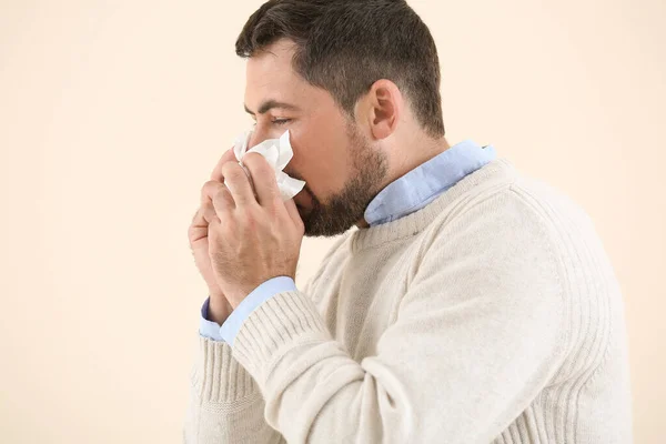 Mężczyzna chory na grypę na lekkim tle — Zdjęcie stockowe