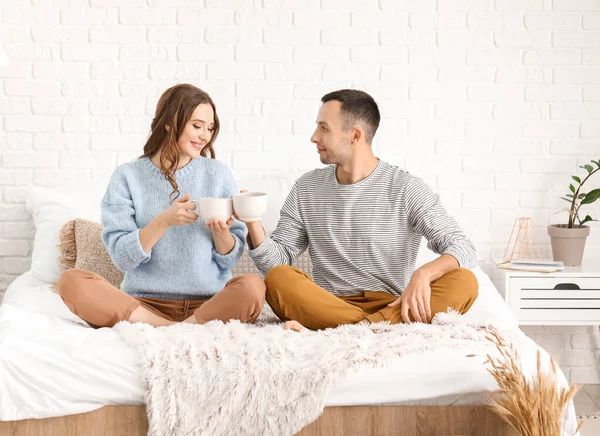 Hermosa pareja joven bebiendo té en la cama en casa —  Fotos de Stock