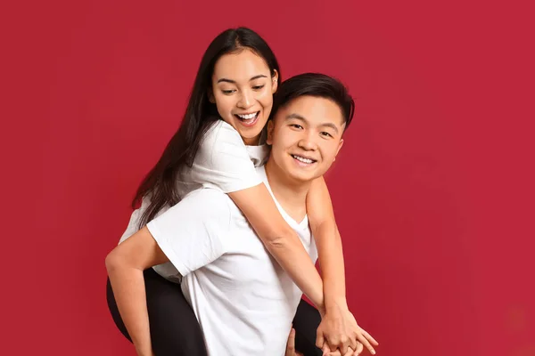 Porträtt av glada unga asiatiska par på färg bakgrund — Stockfoto