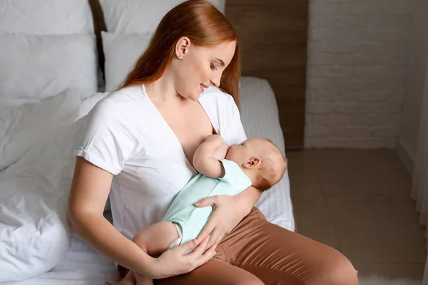 Jonge vrouw borstvoeding haar baby thuis — Stockfoto