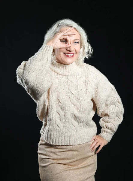 Portrait of stylish mature woman showing OK on dark background — Stock Photo, Image