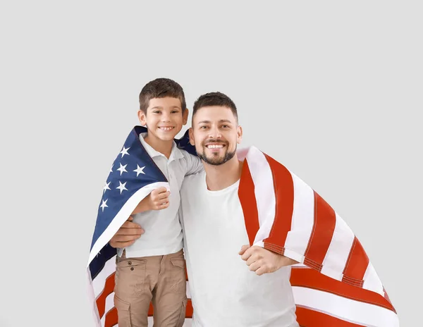 El hombre y su hijo con la bandera de EE.UU. en el fondo claro. Celebración del Día de Memorial — Foto de Stock