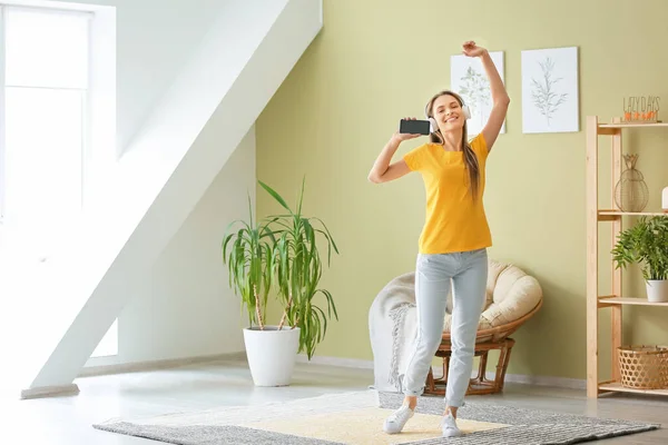 Dansande kvinna lyssnar på musik hemma — Stockfoto