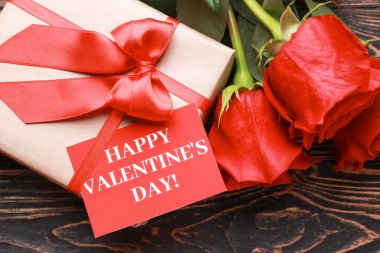 Sevgililer Günü kartı, çiçekler ve tahta arka planda hediye.