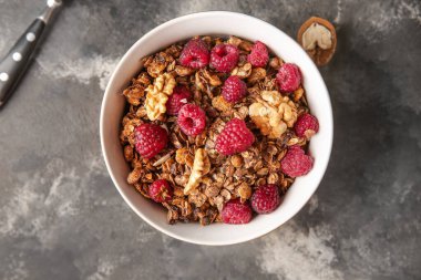 Lezzetli granola ve arkaplanda böğürtlenli kase.