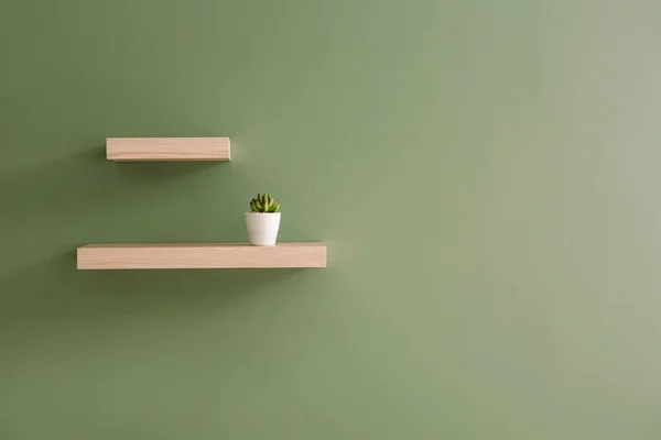 Shelves hanging on color wall — Stock Photo, Image