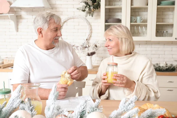 Feliz pareja adulta desayunando en Nochebuena en la cocina —  Fotos de Stock