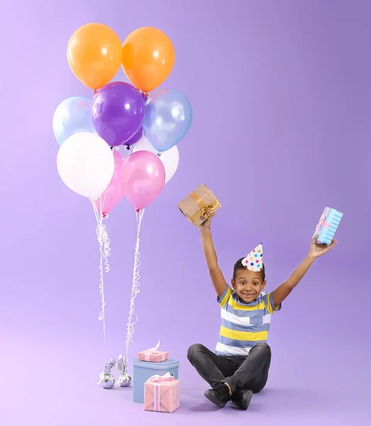 Happy little African-American boy with Birthday air balloons and gifts on color background — Stock Photo, Image