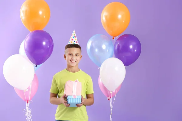 Little boy with Birthday air balloons and gifts on color background — Stock Photo, Image