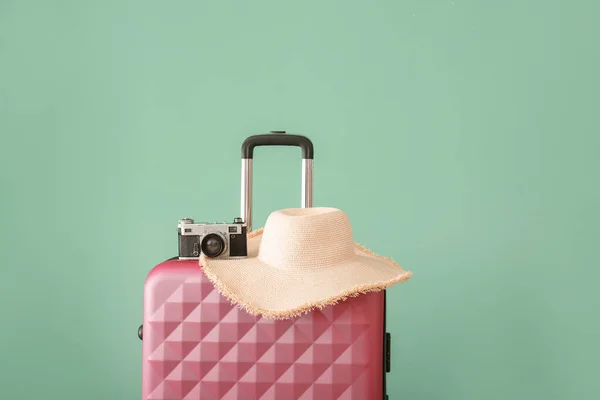 Maleta, cámara fotográfica y sombrero cerca de la pared de color. Concepto de viaje — Foto de Stock