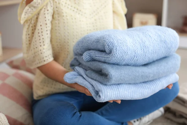 Женщина с пачкой чистой одежды дома, крупным планом — стоковое фото