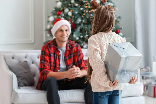 Menina dando presente de Natal para seu pai em casa — Fotografia de Stock