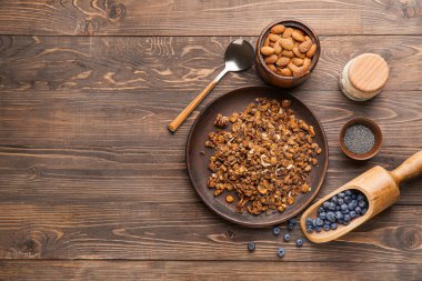 Lezzetli granola tabağı, ahşap masada böğürtlen ve fındık.