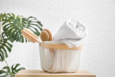 Masada temiz havlu ve fırça dolu sepet.