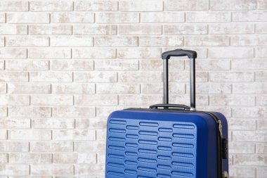 Bavul tuğla duvarın yanında. Seyahat kavramı
