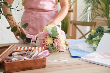 Kadın çiçekçi dükkanda güzel buket yapma