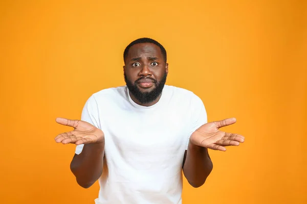 Helpless African-American man on color background — Stock Photo, Image