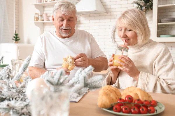 Feliz pareja adulta desayunando en Nochebuena en la cocina —  Fotos de Stock