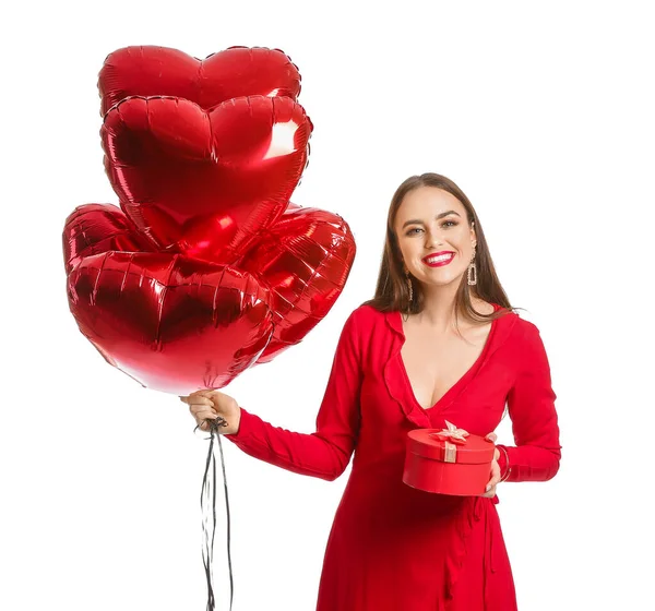 Beautiful young woman with heart-shaped balloons and gift on white background. Valentine's Day celebration — ストック写真