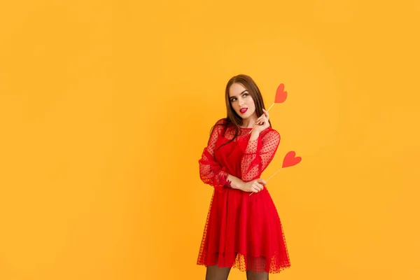 Renkli arka planda kırmızı kalpleri olan güzel bir genç kadın. Sevgililer Günü kutlaması — Stok fotoğraf