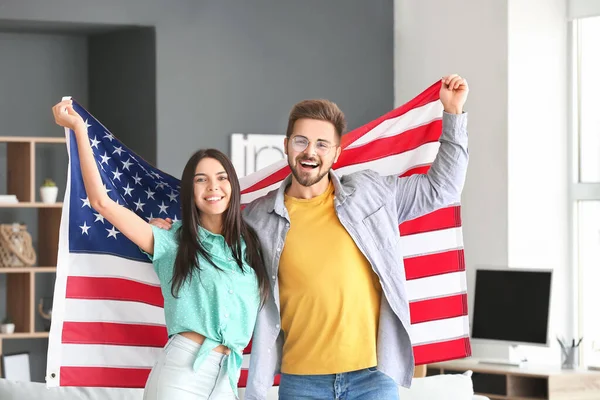 Happy young couple with national flag of USA at home — Stock Photo, Image