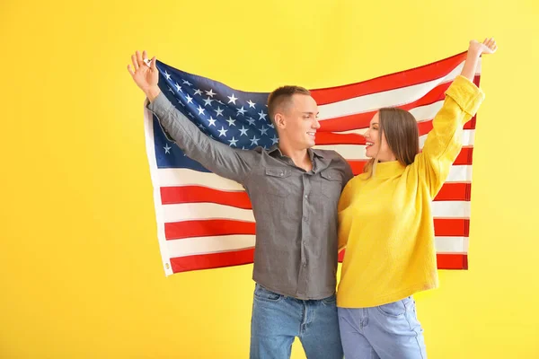 색상 배경에 미국의 국기와 행복한 젊은 부부 — 스톡 사진