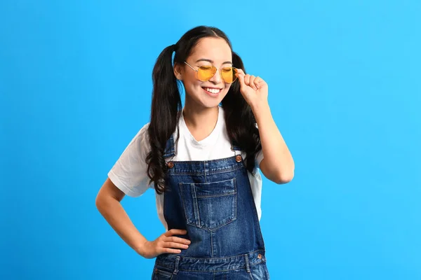 Stylish young Asian woman on color background — Stock Photo, Image