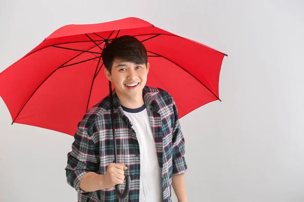 Handsome Asian man with umbrella on white background — Stock Photo, Image