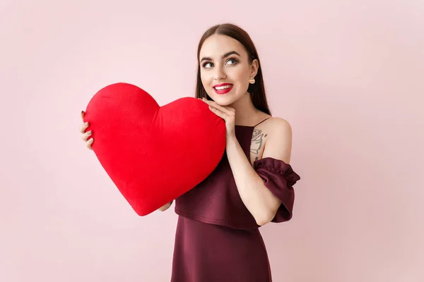Bella giovane donna con grande cuore rosso su sfondo a colori. Festa di San Valentino — Foto Stock
