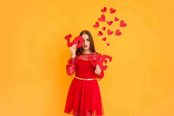 Mulher bonita com palavra AMOR e corações em fundo de cor. Celebração do Dia dos Namorados — Fotografia de Stock