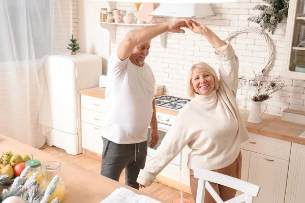 Happy mature couple dancing in kitchen — Stock Photo, Image