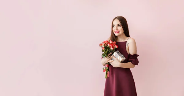 Mulher bonita com flores e presente no fundo de cor. Celebração do Dia dos Namorados — Fotografia de Stock