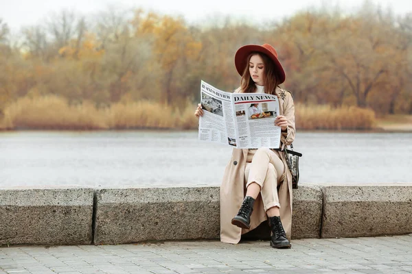 Porträtt av stilren ung kvinna med tidningen utomhus — Stockfoto