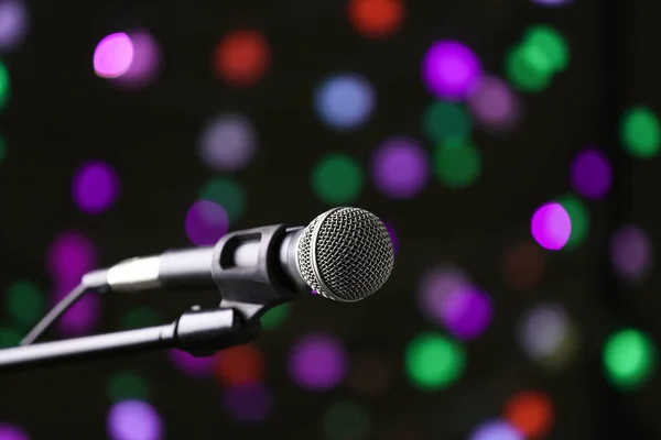 Koyu arkaplanda mikrofon ve sönmüş ışıklar — Stok fotoğraf