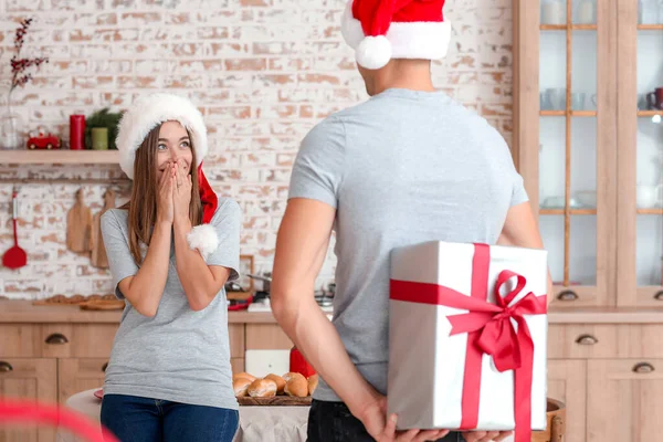 Boldog fiatalember karácsonyi ajándékot ad a barátnőjének otthon. — Stock Fotó