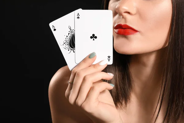 Krásná mladá žena s hracími kartami na tmavém pozadí, detailní záběr — Stock fotografie