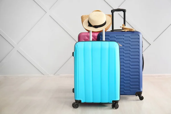 Different suitcases near light wall. Travel concept — Stock Photo, Image