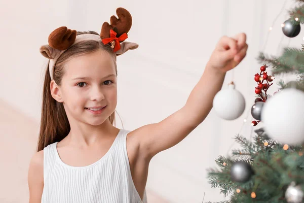 Happy little girl decorating Christmas tree at home — Stock Photo, Image