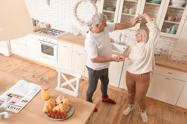 Счастливая зрелая пара танцует на кухне — стоковое фото