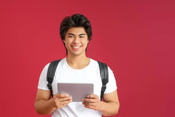 Male Asian programmer with tablet computer on color background — Stock Photo, Image