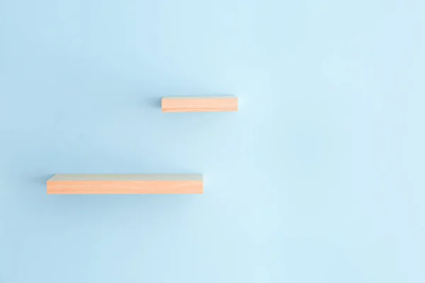 Empty shelves hanging on color wall — Stock Photo, Image