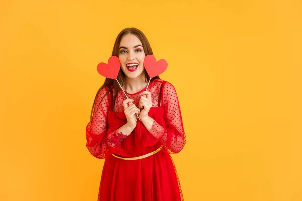 Renkli arka planda kırmızı kalpleri olan güzel bir genç kadın. Sevgililer Günü kutlaması — Stok fotoğraf