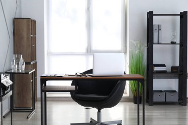 Ofisinde dizüstü bilgisayarı olan modern şık bir iş yeri.