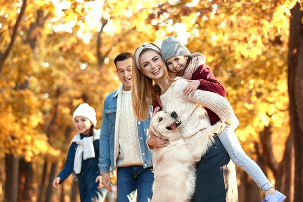 Familia feliz con perro en el parque de otoño —  Fotos de Stock