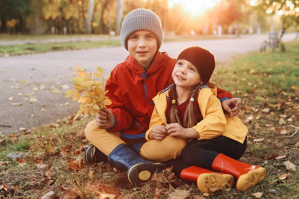 Niños felices descansando en el parque de otoño —  Fotos de Stock