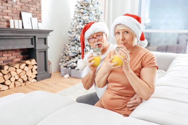 Glad mogen par dricka juice på julafton hemma — Stockfoto