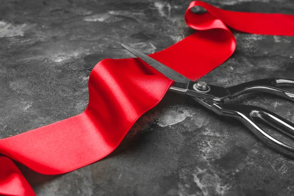 Ножницы и красная лента на фоне гранжа — стоковое фото