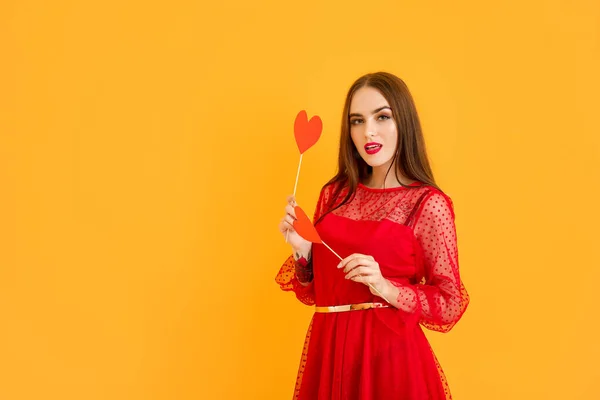 Bella giovane donna con cuori rossi su sfondo a colori. Festa di San Valentino — Foto Stock