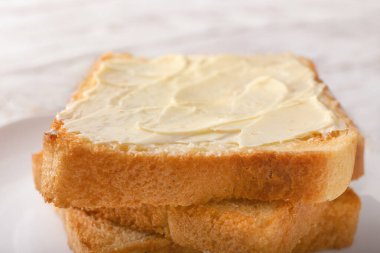 Lezzetli kızarmış ekmek, tabakta tereyağı, yakın plan.