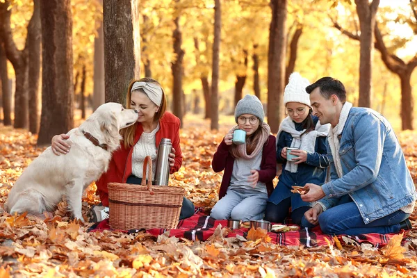 Familia feliz haciendo un picnic en el parque de otoño — Foto de Stock